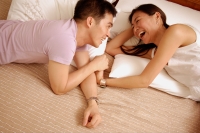 Couple lying in bed, looking at each other - Alex Microstock02