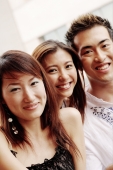 Two young women and one young man, looking at camera, smiling - Alex Microstock02
