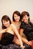 Three young women, sitting side by side, looking at camera - Alex Microstock02