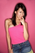 Young woman in pink top, finger in mouth - Alex Microstock02