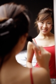 Young woman applying blusher, looking at mirror - Alex Microstock02