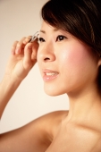 Young woman using eyebrow tweezers - Alex Microstock02