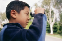 Boy looking through binoculars - Mary Grace Long
