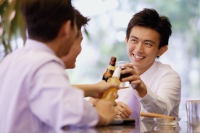 Young men at bar counter toasting with drinks - Alex Microstock02