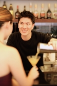 Man holding cocktail mixer, pouring drink for woman - Alex Microstock02