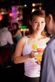 Couple standing, holding drinks, over the shoulder view - Alex Microstock02
