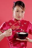 Woman holding bowl of rice and chopsticks, looking at camera - Alex Microstock02