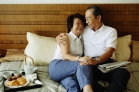 Older couple lying on bed, hugging - Jade Lee