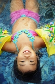 Young girl floating in pool, wearing arm floats - Alex Microstock02
