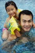 Daughter riding piggyback on father in swimming pool - Alex Microstock02