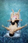 Father and daughter on inflatable bed in swimming pool - Alex Microstock02