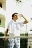 Man drinking from water bottle, holding tennis racket - Alex Microstock02
