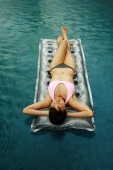 Woman lying on inflatable bed in swimming pool - Alex Microstock02
