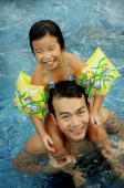 Daughter sitting on shoulders of father, in swimming pool - Alex Microstock02