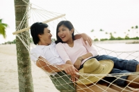 Couple in hammock, looking at each other - Jade Lee