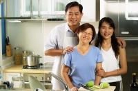 Family with adult offspring, standing in kitchen - Jade Lee