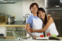 Mother with adult daughter in kitchen, looking at camera - Jade Lee