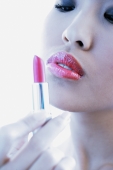 Woman holding and looking at lipstick - Alex Microstock02