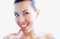 Woman applying lipstick, looking away, smiling - Alex Microstock02