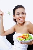 Woman holding bowl of salad, smiling at camera - Alex Microstock02