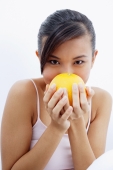 Woman holding orange to face - Alex Microstock02
