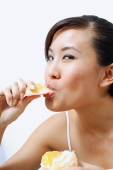 Woman eating orange, looking at camera - Alex Microstock02