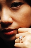 Close up of young woman's face and hand with ring on finger - Alex Microstock02