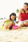 Mother with daughter on beach, playing with sand - Alex Microstock02