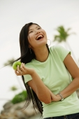 Woman holding apple, laughing, looking away - Alex Microstock02