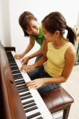 Daughter playing piano, mother next to her - Alex Microstock02