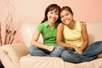 Mother and daughter, sitting on sofa, smiling - Alex Microstock02