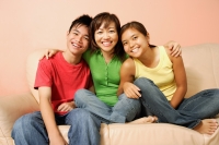 Mother with son and daughter, sitting on sofa, smiling - Alex Microstock02