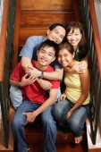 Father and mother sitting on stairs, hugging daughter and son, portrait - Alex Microstock02