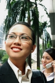 Business woman, smiling, looking away, woman in the background on the phone - Alex Microstock02