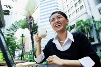 Business woman with laptop, holding coffee cup, smiling - Alex Microstock02