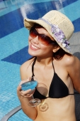  Young woman in bikini, wearing hat and sunglasses, holding cocktail glass, looking away - Alex Microstock02