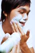 Young man applying shaving foam on face - Alex Microstock02