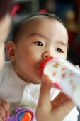 Baby girl drinking from bottle, looking away - Alex Microstock02