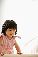 Baby girl leaning on sofa, looking down - Alex Microstock02