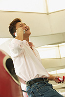 Man holding ring box, using mobile phone, smiling - Alex Microstock02