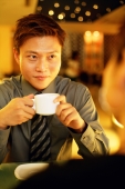 Couple in restaurant, man holding cup - Alex Microstock02