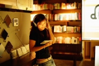 Young woman standing, listening to music, holding CD - Alex Microstock02