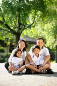 Family looking at camera, sitting on ground - Alex Microstock02