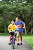 Boy on bicycle, father running behind him, smiling - Alex Microstock02