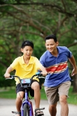 Boy on bicycle, father running behind him - Alex Microstock02