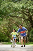 Girl cycling, father running alongside her - Alex Microstock02