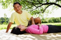 Couple on picnic mat, woman lying down, man sitting looking away - Alex Microstock02