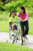 Daughter cycling, mother guiding her - Alex Microstock02