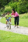Mother guiding daughter on bicycle - Alex Microstock02