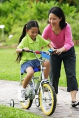 Young girl cycling, mother guiding her - Alex Microstock02